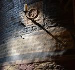 Lumière filtrant à travers les vitraux de la cathédrale Sainte-Cécile d'Albi, laissant renaître les inscriptions latines peintes sur la pierre