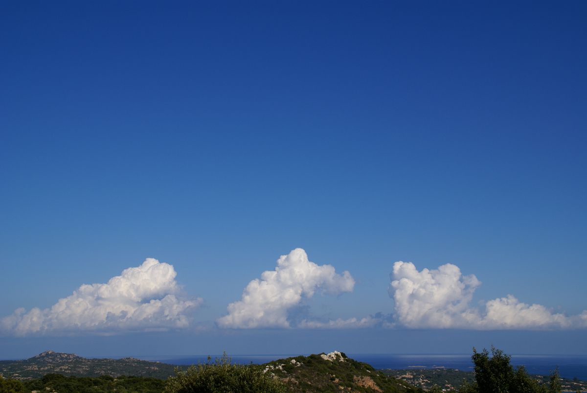 Einen markanten Farbkontrast bilden diese Wolken-Drillinge vor der Küste Sardiniens. Aufgenommen wurde das Bild mit einer Sony Alpha 100, der ersten digitalen Spiegelreflexkamera von Sony.